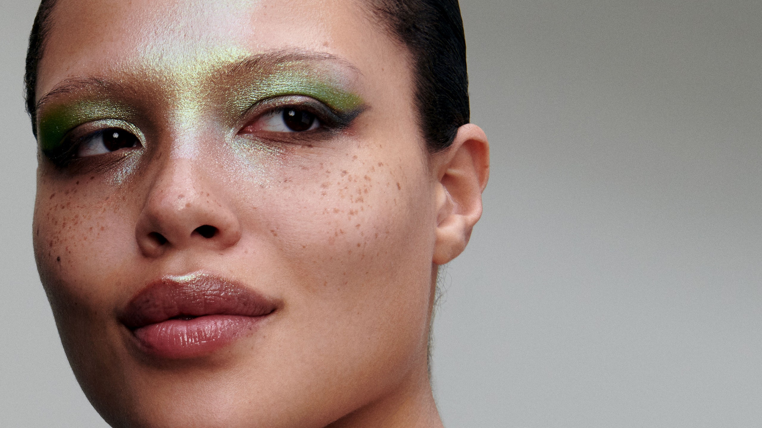 woman wearing sparkling green eye shadow and glitzy blouse