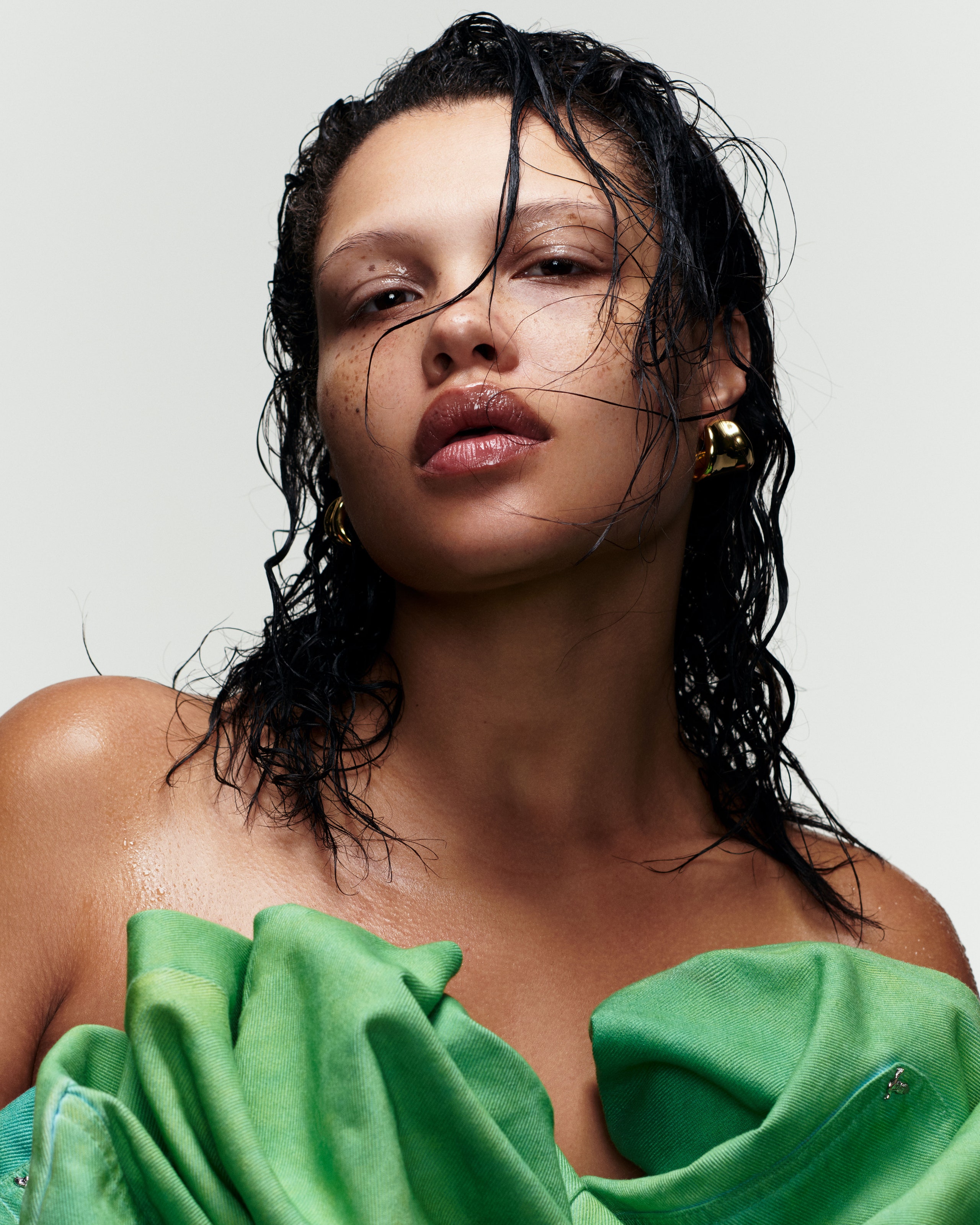 photo of woman wearing shiny lip gloss and wet hair with a green blouse