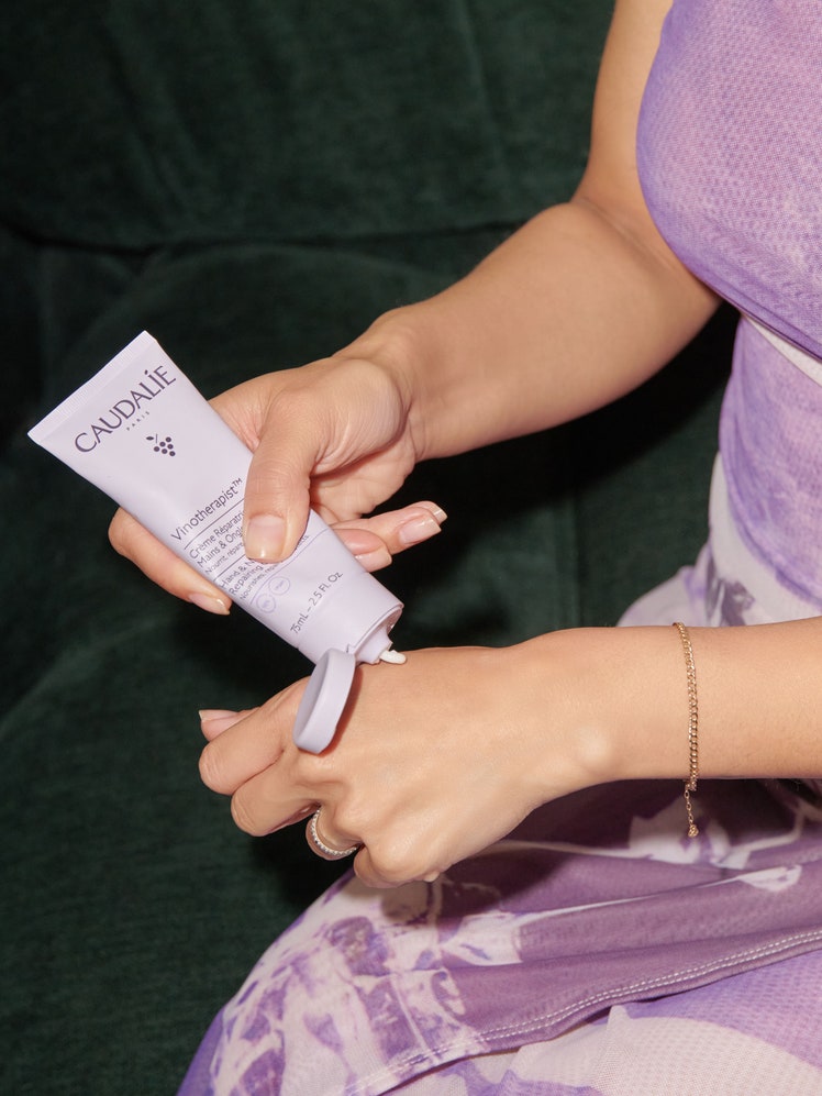 Caudalie Hand  Nail Cream being applied to hand of Shanna Shipin purple packaging