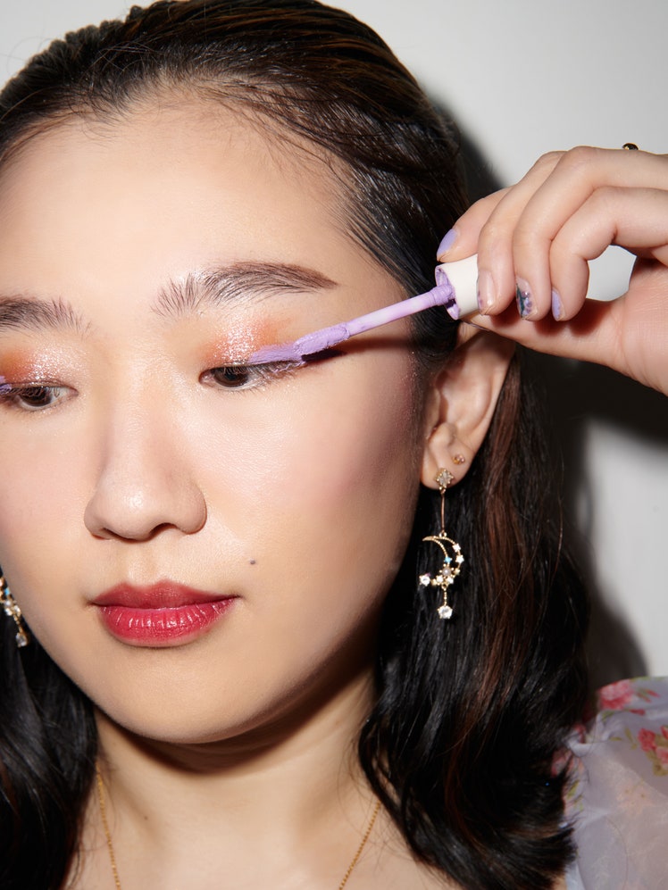 sarah han applying shimmery lilac eyeshadow to eyelids