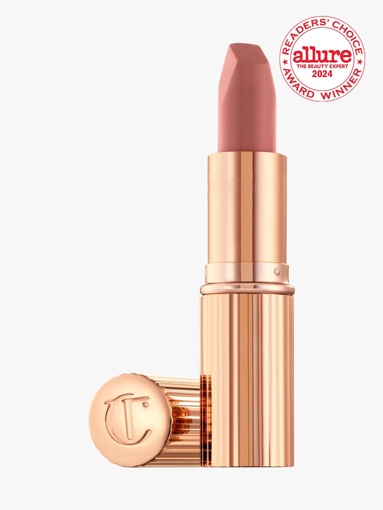 Charlotte Tilbury Matte Revolution Lipstick rose gold tube of nude lipstick with cap to the side on light gray...