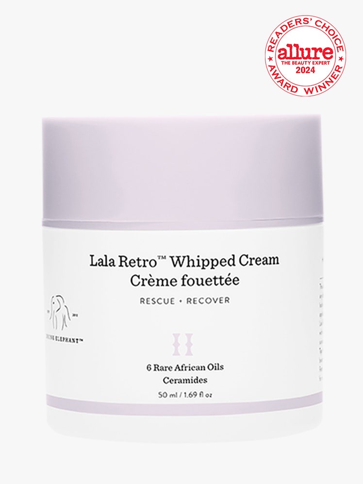 Drunk Elephant Lala Retro Whipped Cream white jar with lavender cap on light gray background with white and red Allure...