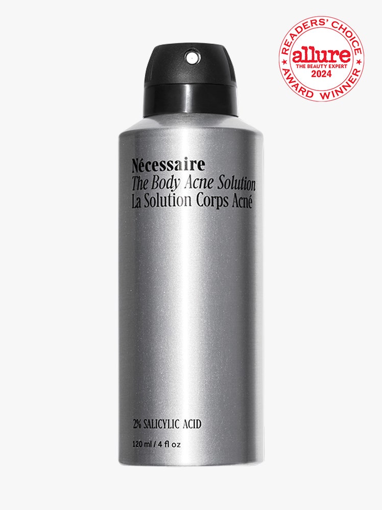 Nécessaire The Body Acne Solution silver metal spray bottle on light gray background with white and red Allure Readers' Choice Award seal in the top right corner