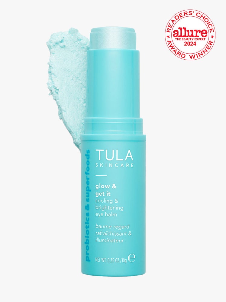 Tula Skincare Glow + Get It Cooling & Brightening Eye Balm turquoise eye serum stick on light gray background with white and red Allure Readers' Choice Award seal in the top right corner