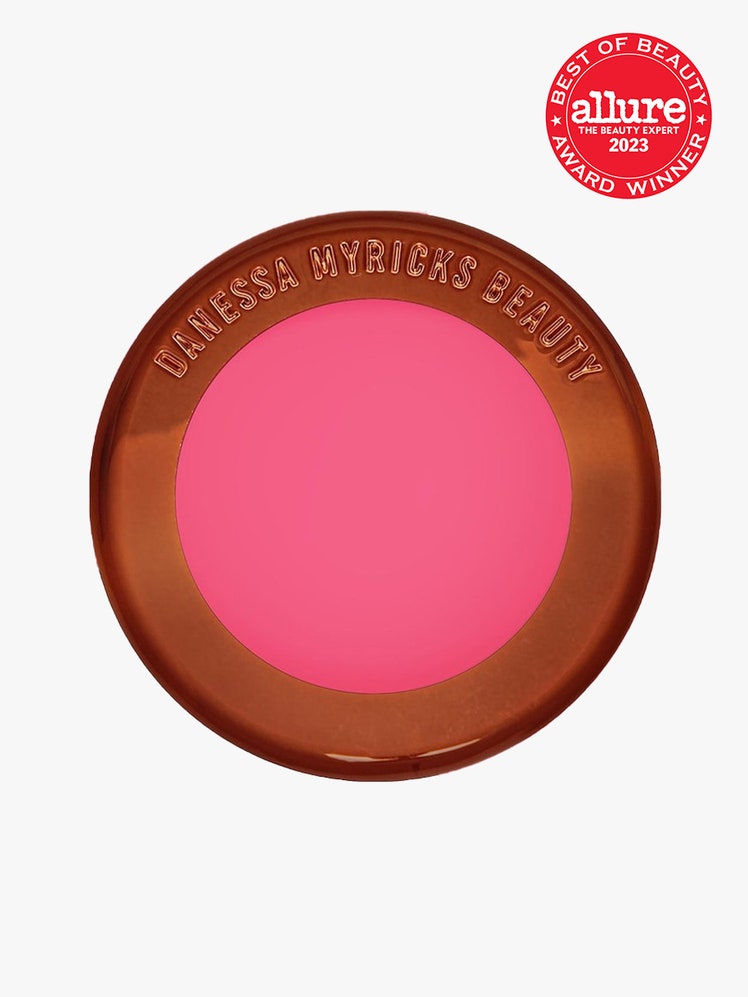 Danessa Myricks Beauty Yummy Skin Blurring Balm Powder Flushed round bronze compact of bright pink blush on light gray...