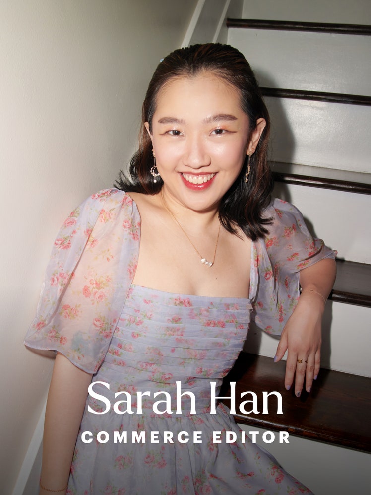 Sarah HanAllure Editor Portrait. Image of a smiling woman sitting back on a stairwell wearing a blue dress with puff...