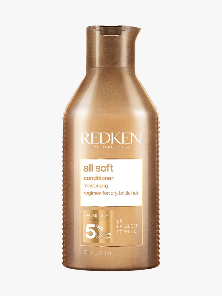 Redken All Soft Conditioner gold bottle of conditioner on light gray background