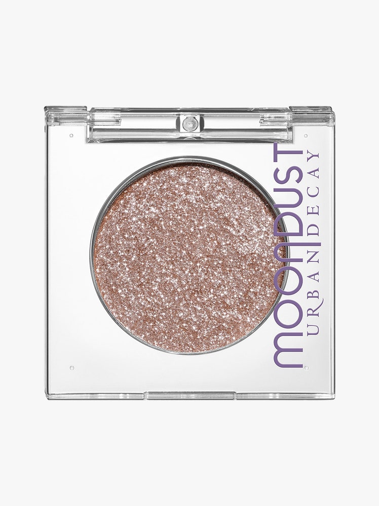 Urban Decay Moondust Eyeshadow clear square compact of sparkly champagne eye shadow on light gray background